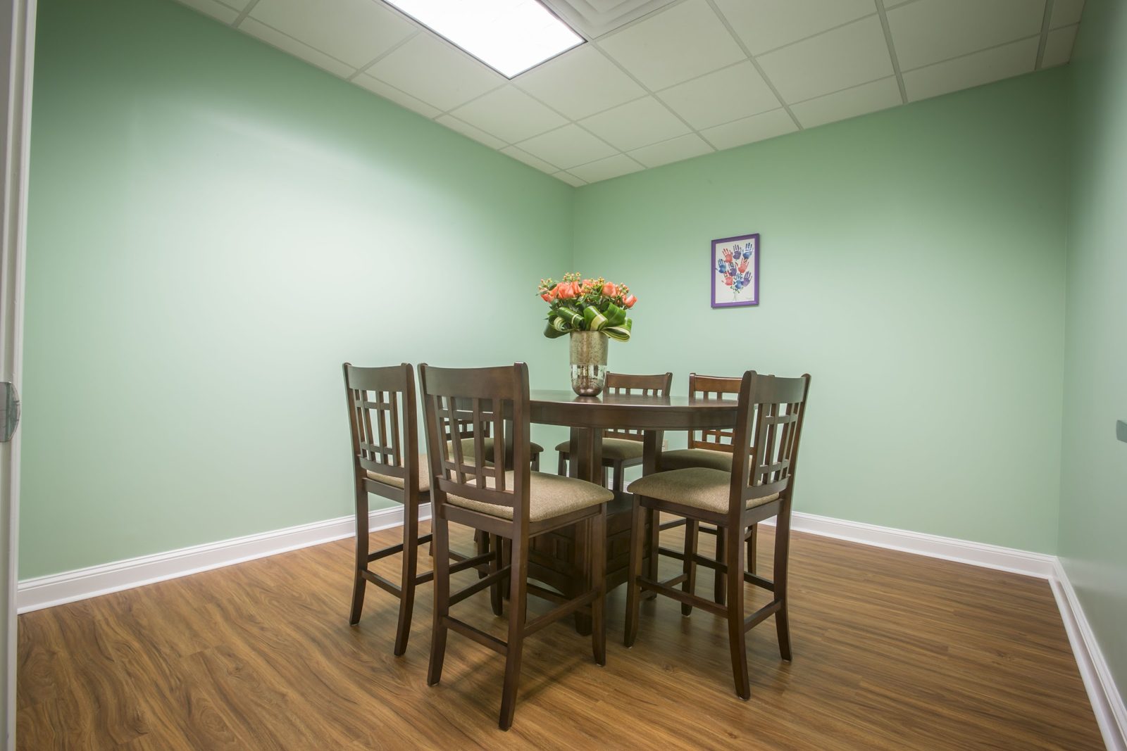 A bright therapy room at TALK with a wooden table and fresh flowers